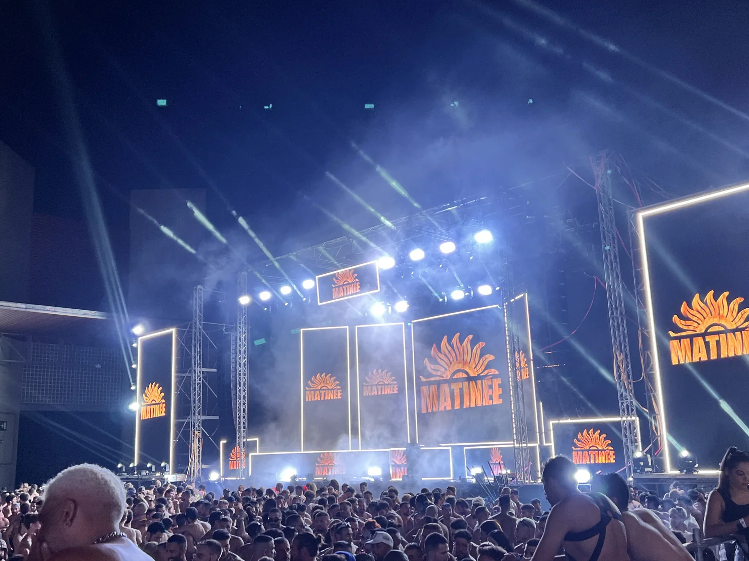 Escenario principal de Matinée de noche, con estructura iluminada, cañones de luz y el público lleno