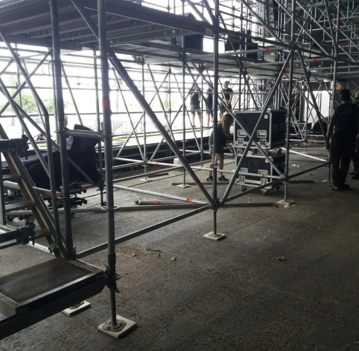Estructura de andamio y truss bajo el escenario durante el montaje