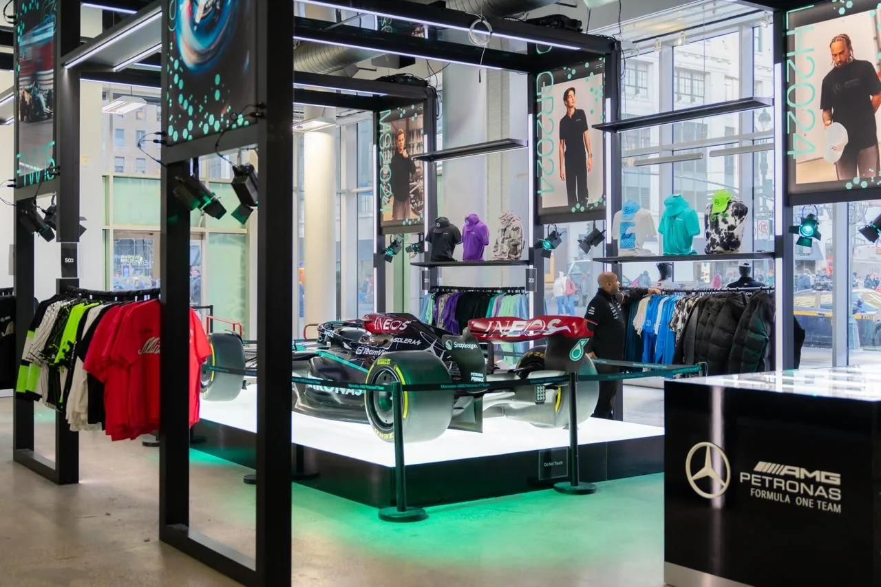 Tienda efímera del equipo Mercedes-AMG PETRONAS con un monoplaza de Fórmula 1 expuesto sobre plataforma iluminada